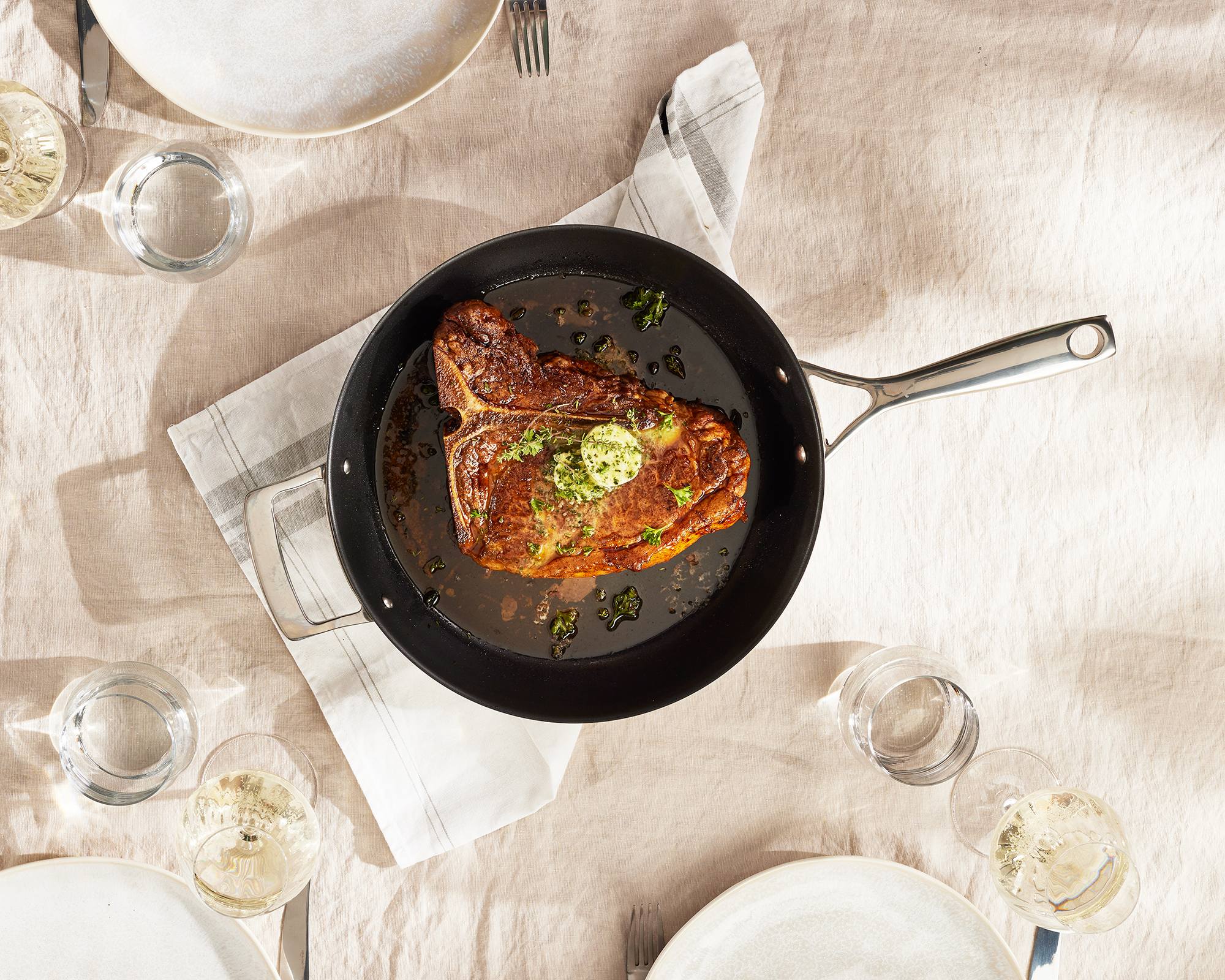 Un steak grille dans une poêle Olavson avec un noyau en cuivre sur la plaque de cuisson